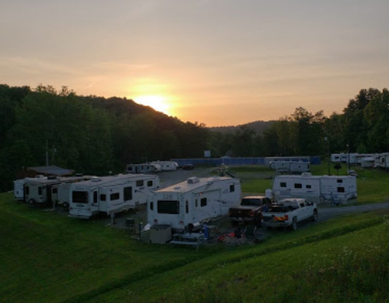 The sun setting over the RVs and wooded hills at State Line Campground.